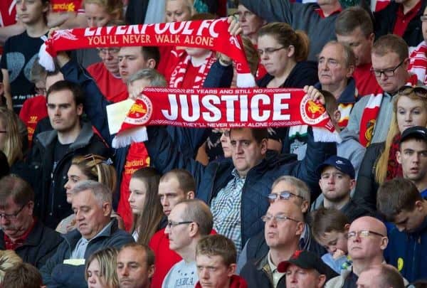 LIVERPOOL, ENGLAND - Tuesday, April 15, 2014: A Liverpool supporter holds up a scarf 'Justice' during the 25th Anniversary Hillsborough Service at Anfield. (Pic by David Rawcliffe/Propaganda)