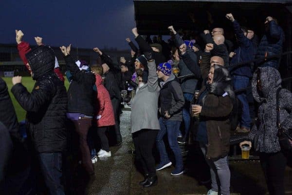 Home supporters celebrating their team's fourth goal at the Delta Taxis Stadium, Bootle, Merseyside as City of Liverpool hosted Holker Old Boys in a North West Counties League division one match. Founded in 2015, and aiming to be the premier non-League club in Liverpool, City were admitted to the League at the start of the 2016-17 season and were using Bootle FC's ground for home matches. A 6-1 victory over their visitors took 'the Purps' to the top of the division, in a match watched by 483 spectators.