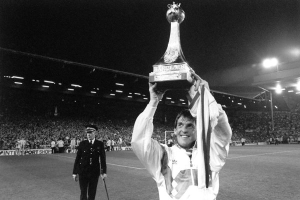 Liverpool player/manager Kenny Dalglish holds up one of the two league championship trophies for the fans at Anfield, after helping his side to beat Derby County 1-0. Dalglish came on as a substitute after 71 minutes; 10 minutes later Gary Gillespie scored the only goal.