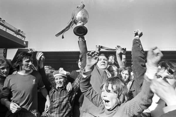 Liverpool manager Bill Shankly holds aloft the League Championship trophy at Anfield today, and the joy on the face of the young supporter says it all. Liverpool just clinched the title by drawing 0-0 with Leicester. 1973 (PA Images)