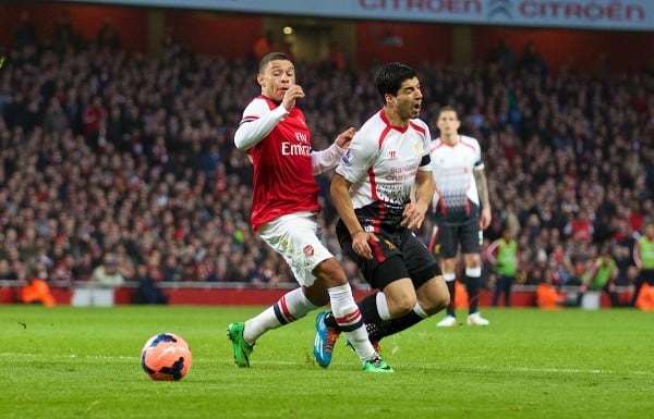 LONDON, ENGLAND - Sunday, February 16, 2014: Liverpool's Luis Suarez is hacked down by Arsenal's Alex Oxlade-Chamberlain but amazingly no penalty was given during the FA Cup 5th Round match at the Emirates Stadium. (Pic by David Rawcliffe/Propaganda)