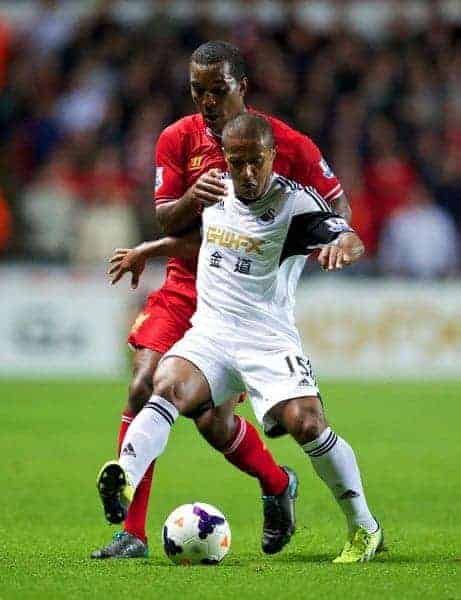 SWANSEA, WALES - Monday, September 16, 2013: Liverpool's Andre Wisdom in action against Swansea City's Wayne Routledge during the Premiership match at the Liberty Stadium. (Pic by David Rawcliffe/Propaganda)